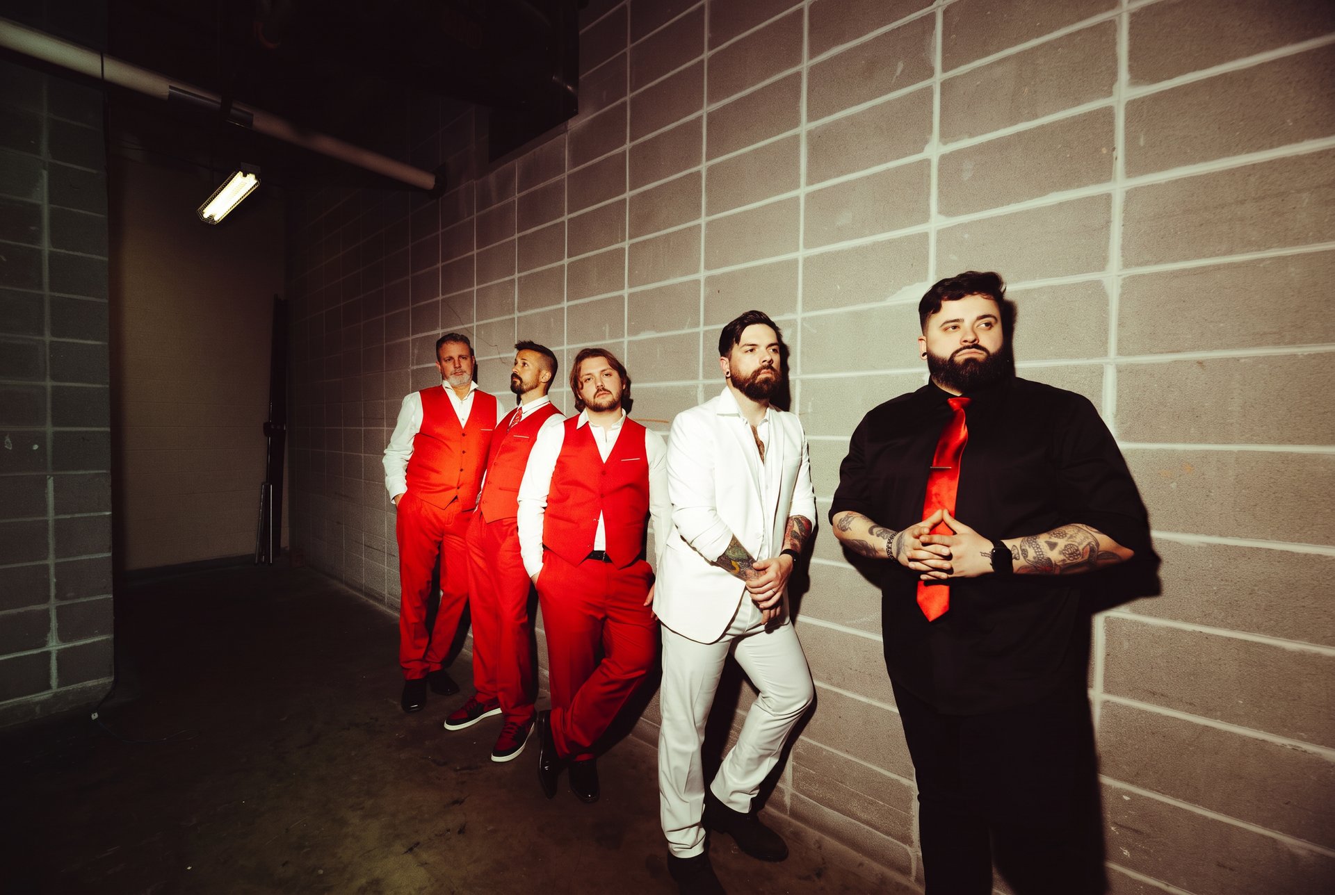 Count The Years promo shot in red suits against a cinder block wall